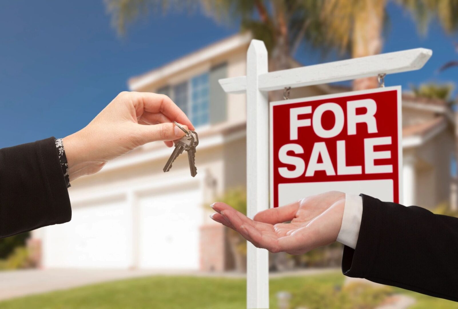 Land for sale. Hand, handing out the key to a property
